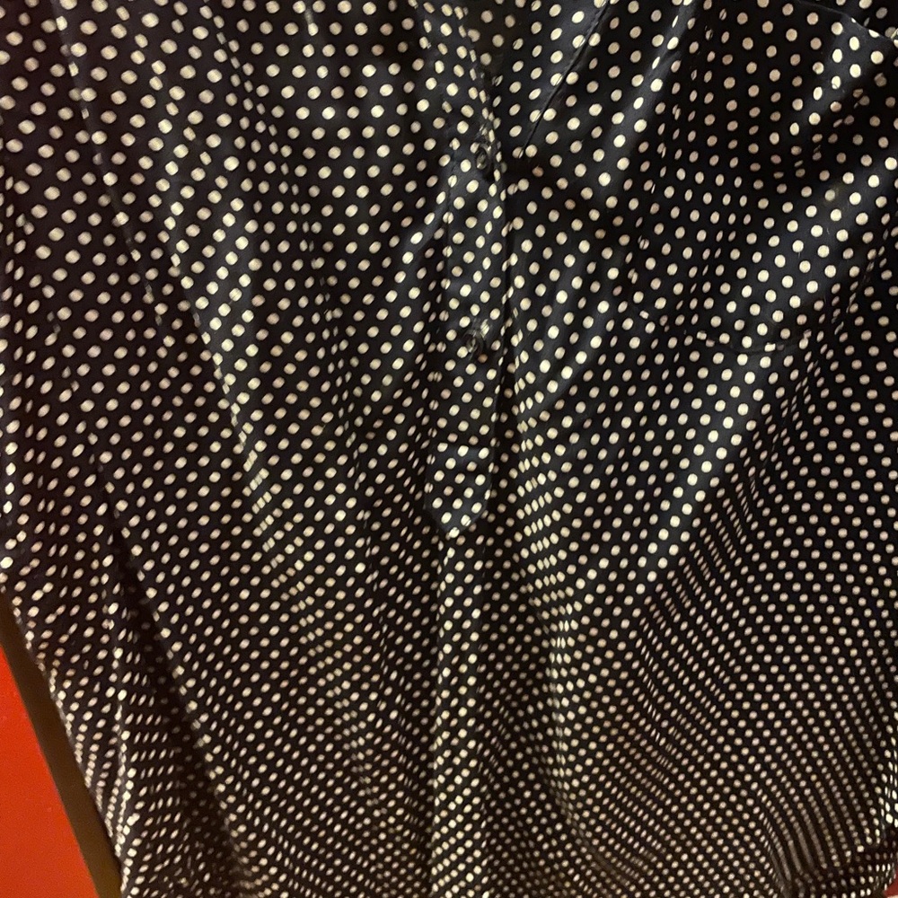 Sleeveless navy blue/white polka dot blouse.